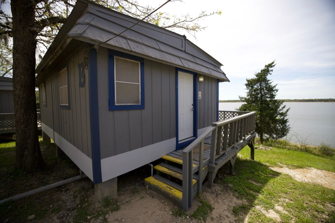 Cabin B at Overlook Park & Marina, a grey cabin with blue trim on the bluff beside Lake Somerville