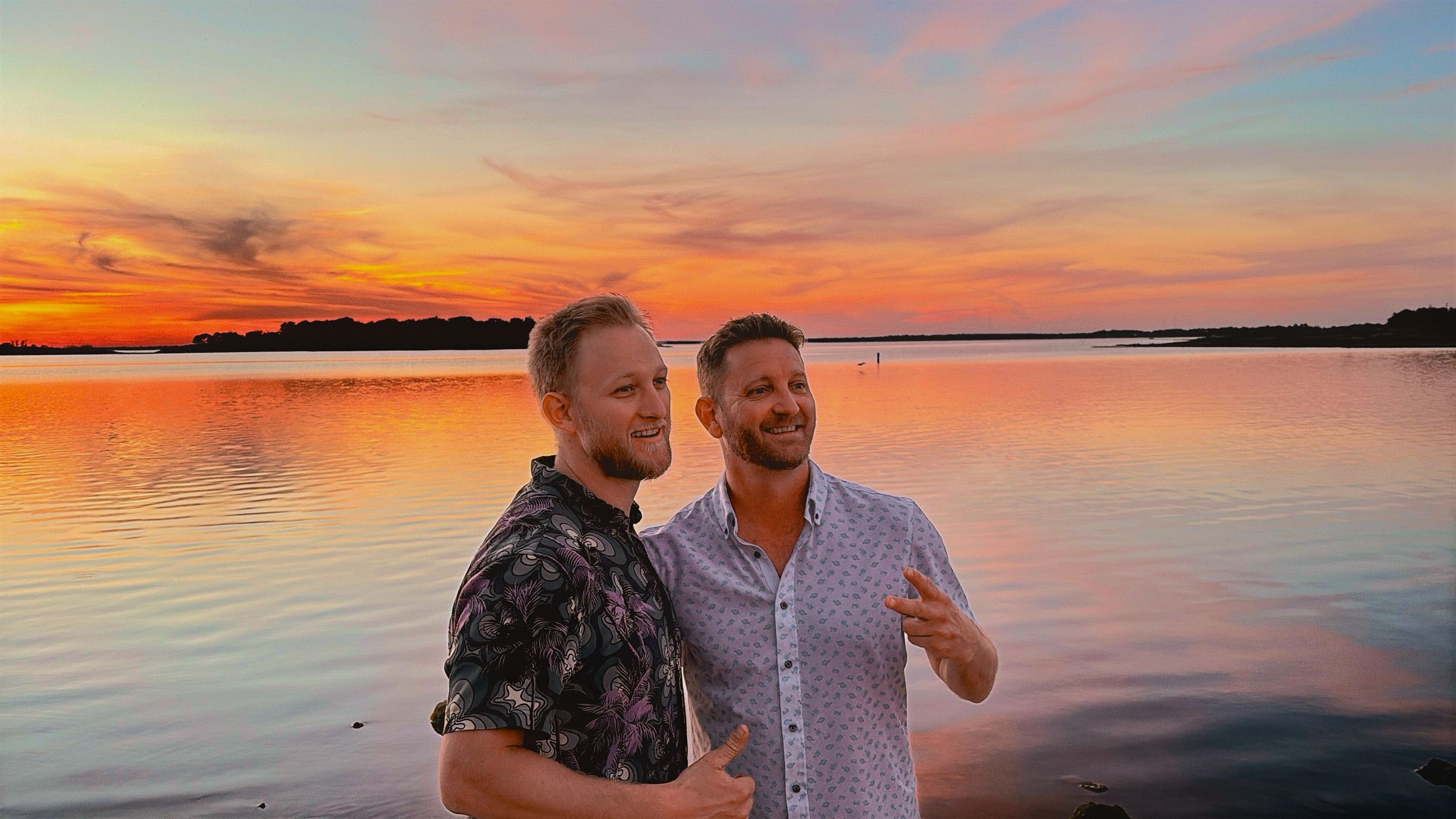 Harley and Tyler Schild smiling in front of a vivid sunset over Lake Somerville.